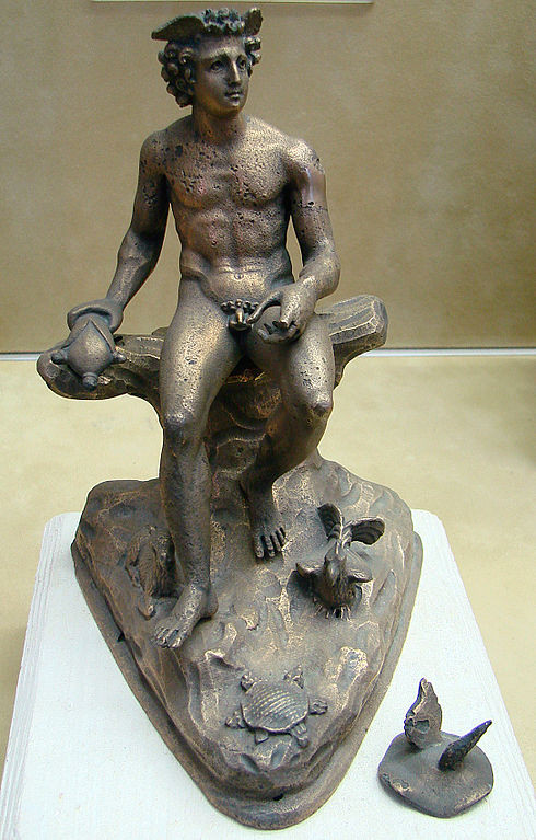 A front-facing, full-color photo of a golden bronze figurine of a fully-nude, muscular Mercury sitting slouched on an unnatural, almost T-shaped rock. The figurine's platform has no decoration and is shaped unevenly to look like the natural Earth or a rock. Mercury's right leg sticks out while He holds His left leg back. His left hand rests on His thigh with fingers closed like it once held something (perhaps a caduceus). His right hand rests to the side on the rock carrying a strange purse (almost in the shape of a turtle). His face looks up towards the left, with an innocent or even pouting expression in His eyes. His hair is thickly curled with two wings popping out over His forehead. A tiny lamb lies at His right foot, a rooster sits by His right, and a tortoise lies in front, facing towards Him. Of to the side is a flat, round cap with two wings popping out of the top, fully detached from the rest of the figurine.
